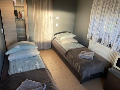 two twin beds in a small room with a window at Pokój u Patki in Rowy