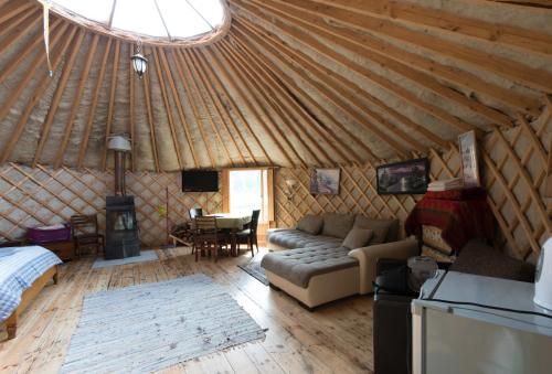 a living room with a couch and a table in a yurt at Yurtos in Gaugariai