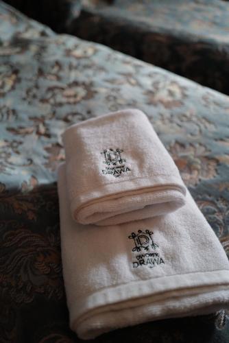 a towel sitting on top of a bed at Dworek Drawa in Drezdenko