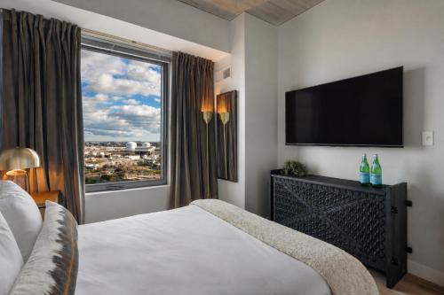 a hotel room with a bed and a large window at Hyatus Designer Residences Somerville in Somerville