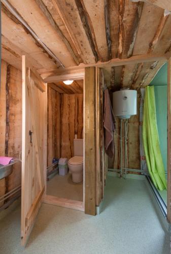 a bathroom with a toilet in a wooden house at Yurtos in Gaugariai
