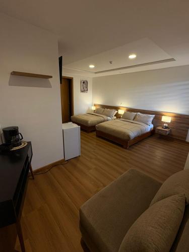 a living room with two beds and a couch at Hotel San Benito Cuenca in Cuenca