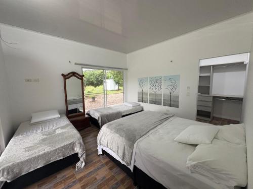 a bedroom with two beds and a window at Aguakey in Tauramena