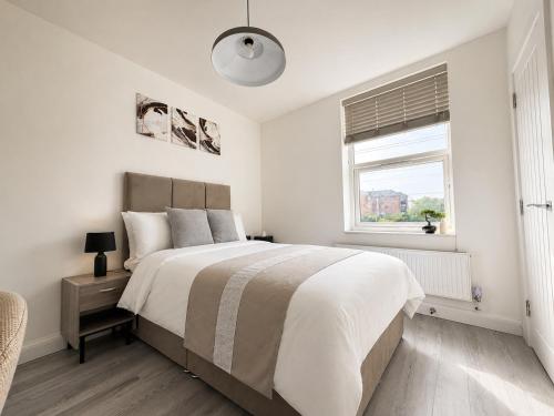 a white bedroom with a large bed and a window at ExecStay - Central Reading - Premium Solo Stays in Reading