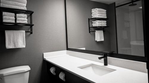 a bathroom with a sink and a mirror and a toilet at Clifton Victoria Inn at the Falls in Niagara Falls
