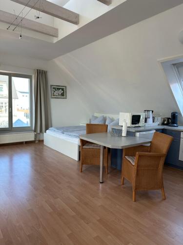 a room with a bed and a table and chairs at Birnbom Warnemünde in Warnemünde