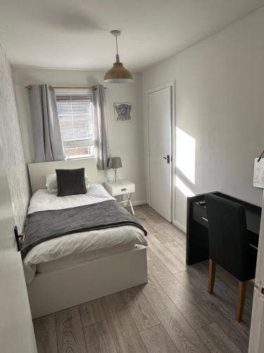 a bedroom with a bed and a desk and a window at Impala Apartment in Wick