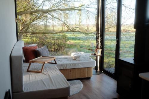 a living room with a couch and a large window at NOAH Cabin No2 - An wunderschöner Windmühle in Beverstedt