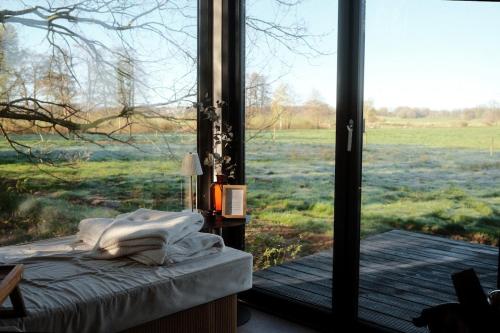 a bedroom with a view of a field through a window at NOAH Cabin No2 - An wunderschöner Windmühle in Beverstedt