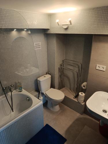a bathroom with a toilet and a tub and a sink at Matróz Lak Apartman in Alsóörs