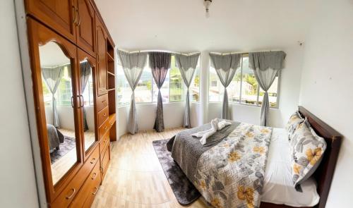 a bedroom with a bed and a large mirror at Hostal El Viajero-Mindo in Mindo