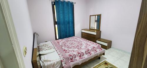 a bedroom with a bed with a dresser and a mirror at Green View Compound Apartment in Alexandria