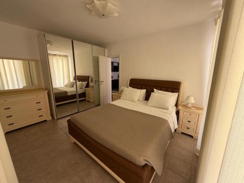 a bedroom with a bed and a large mirror at Villa Busho in Naousa