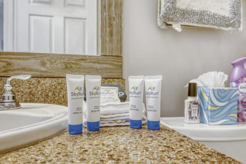 a bathroom counter with three tubes of sunscreen on it at Relaxed Poolside Gym Escape in Green Cove Springs