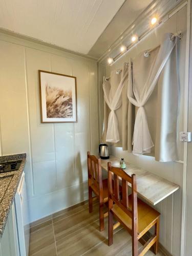 a dining room with a table and two chairs at 12 · Studio 22 Itajaí microcasa in Itajaí