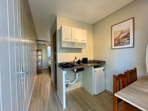 a kitchen and dining room with a table and a counter at 12 · Studio 22 Itajaí microcasa in Itajaí