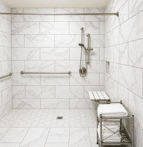 a white tiled shower with a bench in a bathroom at El Dorado Motel in Twain Harte