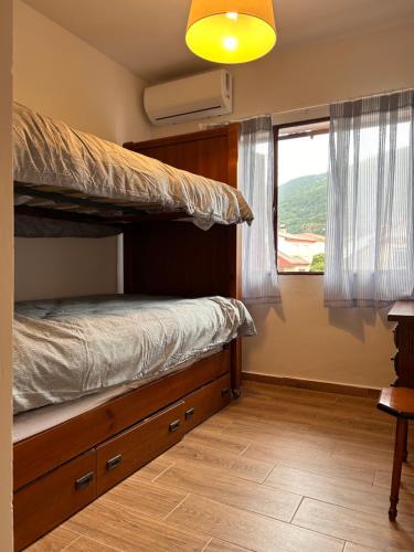 a bedroom with a bunk bed and a window at Casa rural en La Adrada con jardín in La Adrada