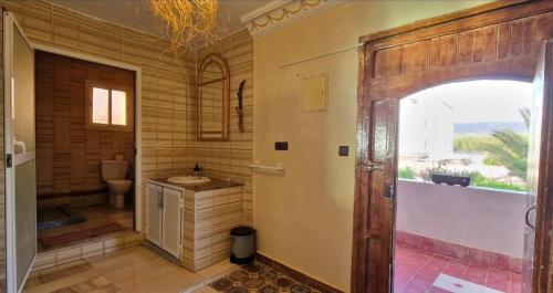 a bathroom with a sink and a toilet in a room at Villa Galactik Pegasus in Tamraght Ou Fella
