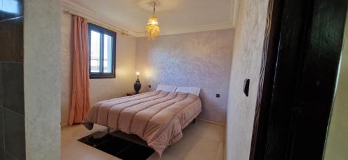 a bedroom with a bed and a window at Villa Galactik Pegasus in Tamraght Ou Fella
