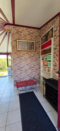a red bench in a room with a brick wall at Maison Parentis en Born 6-8 personnes-L'échappée landaise in Parentis-en-Born