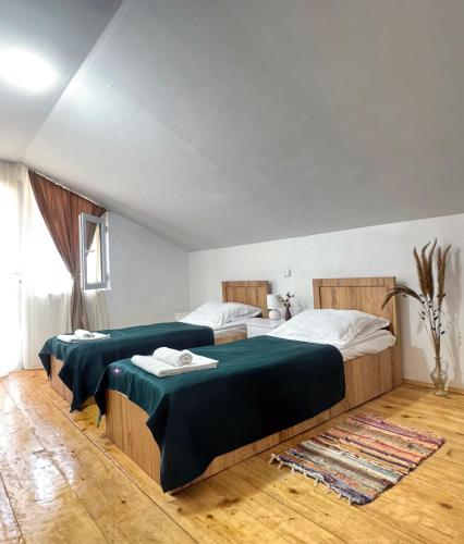 a bedroom with two beds with green sheets at Cozy cottage in Biisi in Biisi