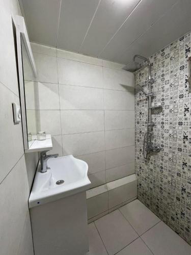 a white bathroom with a sink and a shower at Cozy cottage in Biisi in Biisi