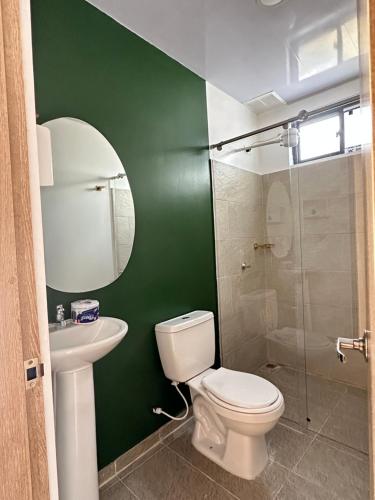 a green bathroom with a toilet and a sink at Casa Lemora in Vergara