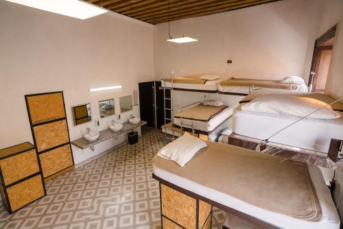 a room with four beds in it with a room with at Casona Poblana Hotel Puebla in Puebla