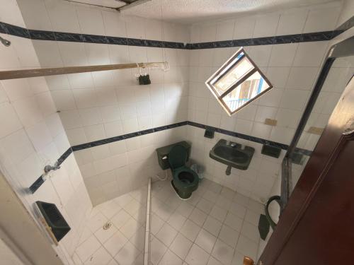 ein kleines Badezimmer mit Toilette und Fenster in der Unterkunft Hotel Astoria in Melgar