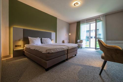a bedroom with a large bed and a large window at Cozmoss Boutique Hotel in Erica