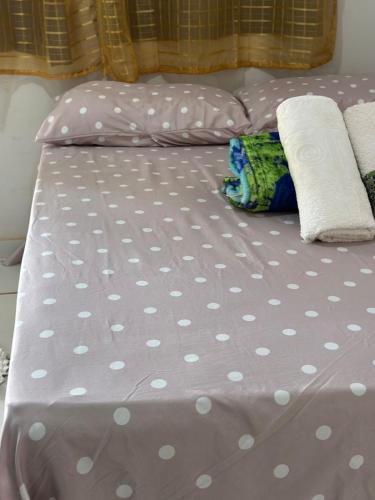 a bed with white polka dot sheets and a pillow at Pousada são Martins in Estivado