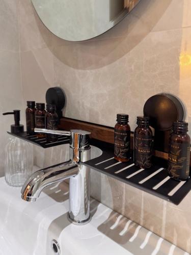 a bathroom sink with a faucet and jars on a shelf at Gregory Central Apartment in Chania