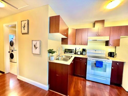 a kitchen with wooden cabinets and a white stove top oven at The Royal Suite in Surrey