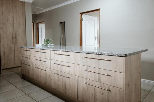 a kitchen with a large wooden cabinet with a counter top at Melk en Heuning Uitspan in Orania