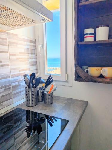 a kitchen with a counter with utensils on it at ESPRESSO VISTA MARE, Ostia Antica in Lido di Ostia