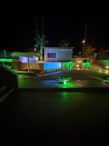 a night view of a building with green lights at Jimmy's place in Artemida