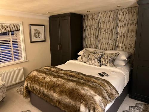 a bedroom with a large bed with a blanket on it at 2 Bed Cottage - Bawtry Superb Accommodation in Bawtry