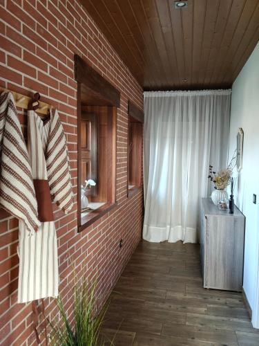 a room with a brick wall and a window at MINI PICONEIRO II in Pravia