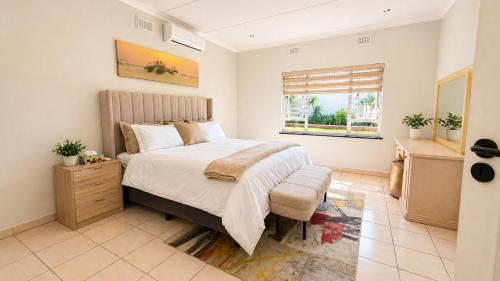 a bedroom with a large bed and a window at Umhlanga La Lucia Oasis, Family Friendly Accommodation in Durban