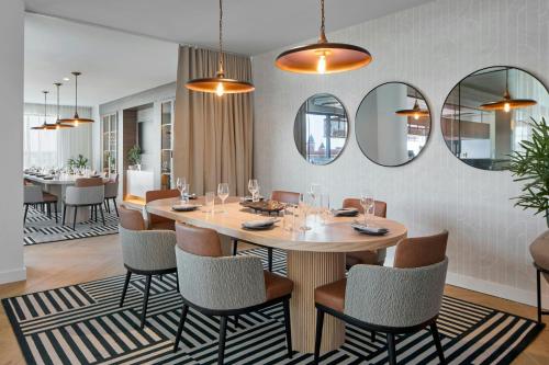 a dining room with a table and chairs and mirrors at AC Hotel by Marriott Auburn in Auburn