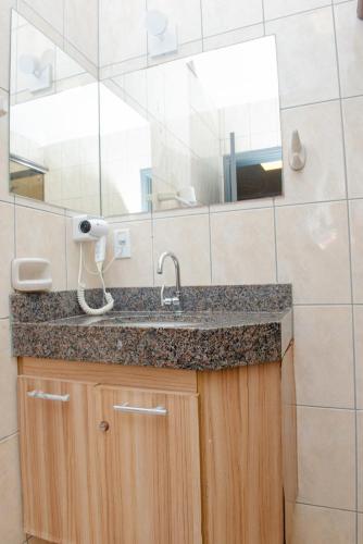 a bathroom with a sink and a mirror at Hotel Universitario in Itapetininga