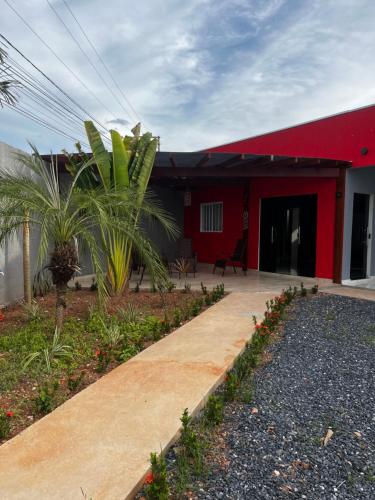 a red building with a sidewalk in front of it at PousadaOasis in Várzea Grande