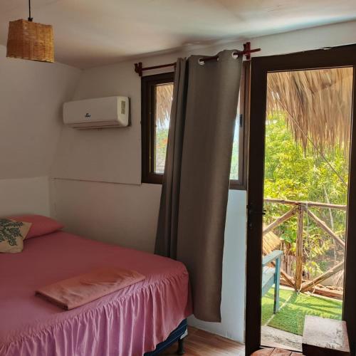 a bedroom with a bed and a window with a balcony at El Puente in El Paredón Buena Vista