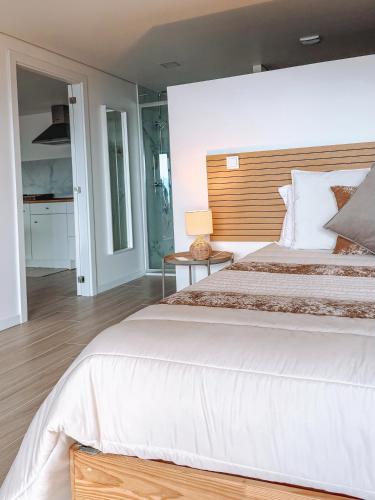 a bedroom with a large bed with a wooden headboard at Caniçada Home in Vieira do Minho