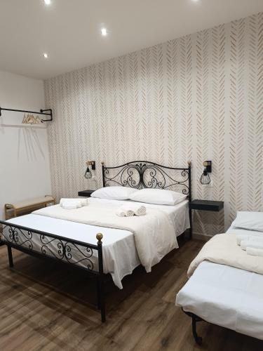 a bedroom with two beds with white sheets at Almía apartment in Cinisi