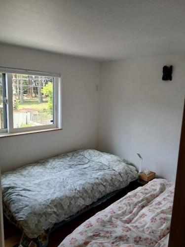 a bedroom with a bed next to a window at Guesthouse Oomiyabase25 大宮基地 別荘新館 in Chiba
