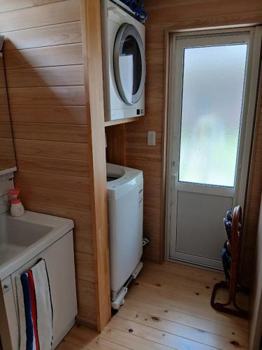 a small kitchen with a washing machine and a window at Guesthouse Oomiyabase25 大宮基地 別荘新館 in Chiba