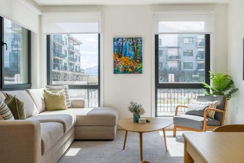 a living room with a couch and some windows at Summit Central in Revelstoke