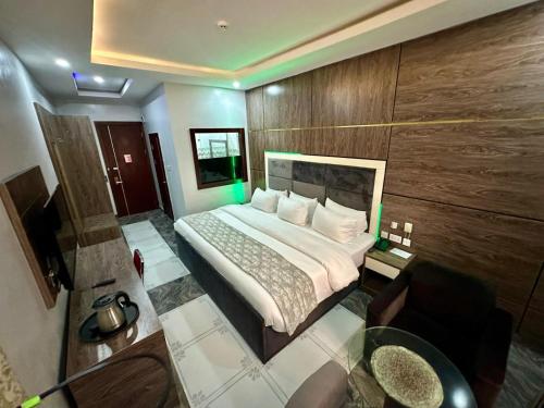 a bedroom with a bed and a desk and a television at Chinbell Luxury Hotel & Suites in Lekki